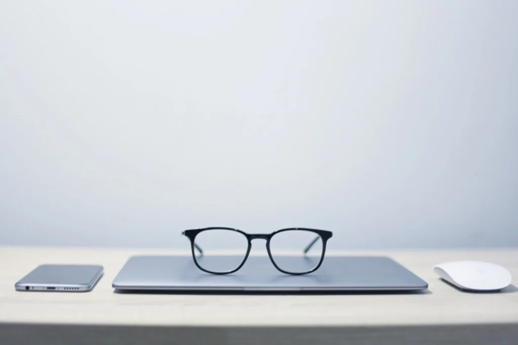 Minimalistischer Arbeitsplatz mit geschlossener Brille auf Laptop – modernes und aufgeräumtes Homeoffice-Setup